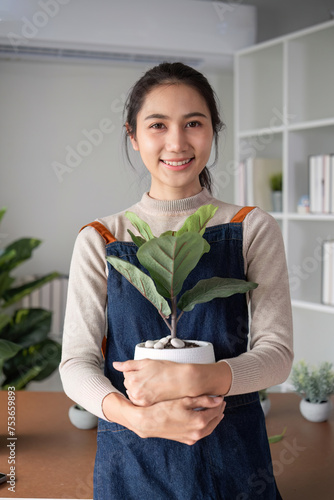 A young Asian woman is enjoying planting a garden in her home to create a shady atmosphere in her home.