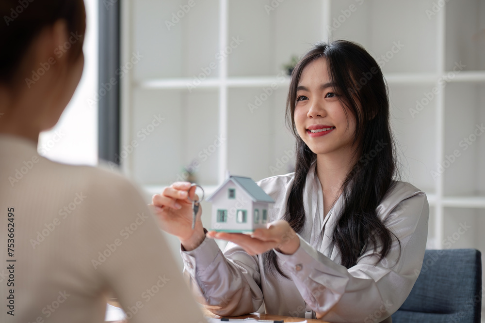 Fototapeta premium Home sales and real estate agent provide home models to clients to complete sale contract with.