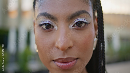 Gorgeous model looking camera at sunny downtown portrait. Cosmic african woman