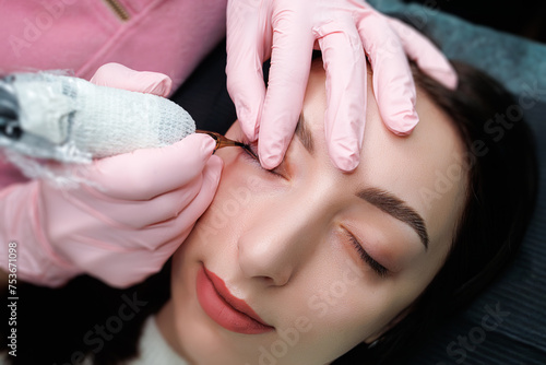 Girl model at the procedure of permanent makeup of eyelashes. Permanent eye makeup and PMU eyelashes