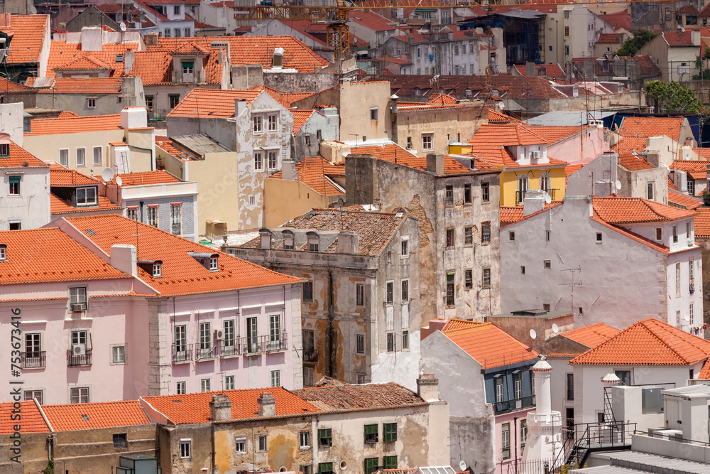 Cityscape of colorful traditional houses in Lisbon historic center, Portuguese red rooftops, balconies, antenna, and construction, Portugal
