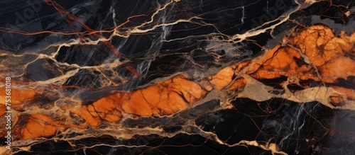 Close up of polished black and orange marble texture with intricate veins