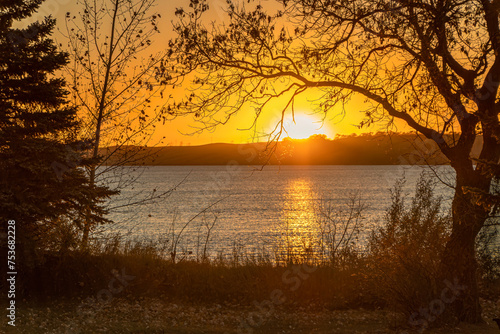 Golden Coloured, Shimmering Waters Sunset over Blackstrap Lake in Saskatchewan photo
