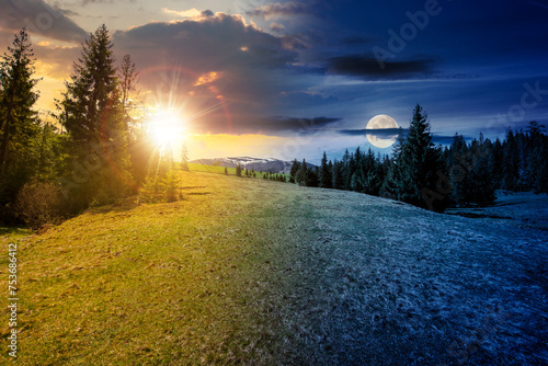 mountain landscape with sun and moon at spring equinox. meadow on the hillside with coniferous forest. day and night time change concept. mysterious countryside scenery in morning light © Pellinni