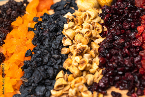 Dried fruits arrangement includes raisins, goldenberries, figs, and apricots, presenting a vibrant and nutritious array photo