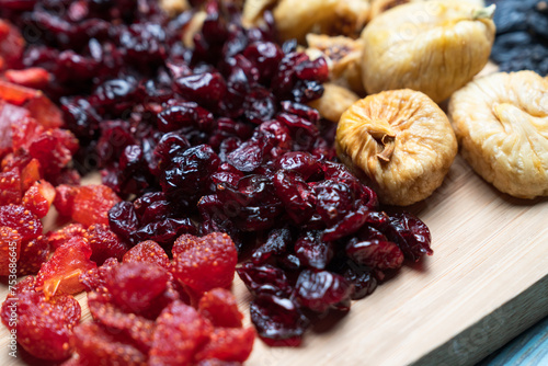 Dried fruits arrangement includes raisins, goldenberries, figs, and apricots, presenting a vibrant and nutritious array photo