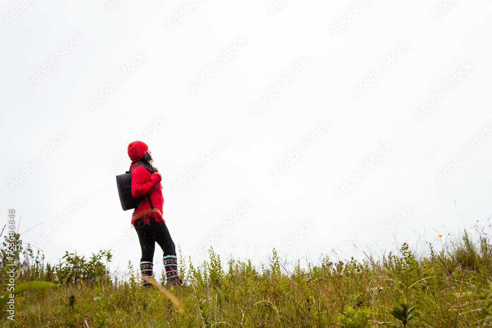 Explorando el invierno Chica con mochila y chompa rojo disfrutando del paisaje campestre bajo un cielo nublado,turista viajero,estilo de vida Explorando el invierno Chica con mochila y chompa rojo disfrutando del paisaje campestre bajo un cielo nublado,turista viajero,estilo de vida