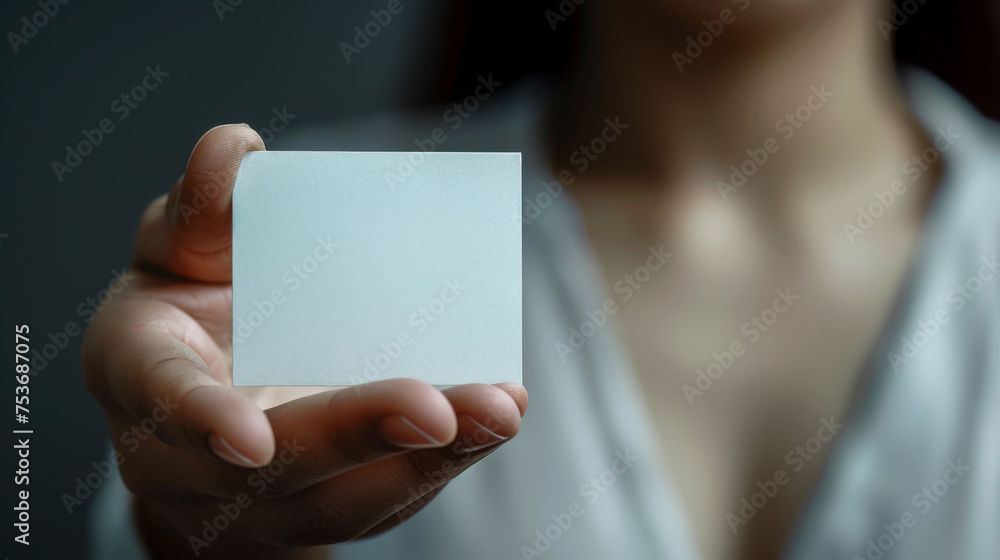 Man's hand showing business card - closeup shot on grey background. Man's hand showing business card - closeup shot on grey background.
