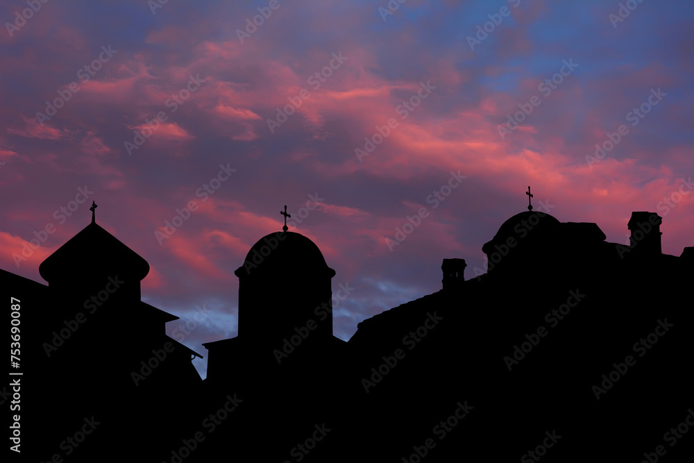 Greek monastery silhouettes in Byzantine style in sunset