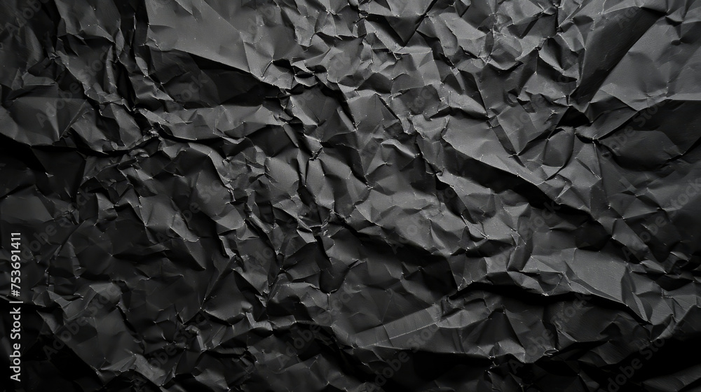 Black crumpled paper texture in low light for abstract backgrounds Black crumpled paper texture in low light for abstract backgrounds