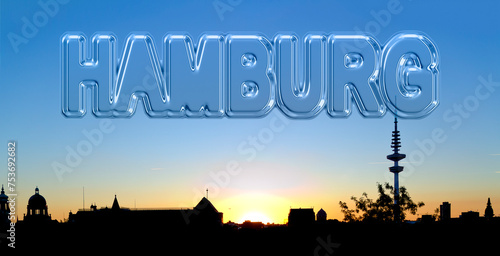 glassy lettering "HAMBURG" on the sky above the silhouette of Hamburg at sundown, Germany