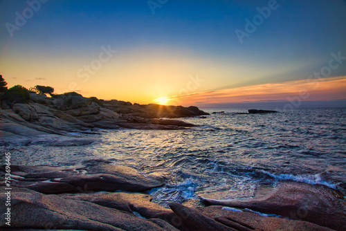 Amanecer en Paisaje de playa y rocas junto al mar