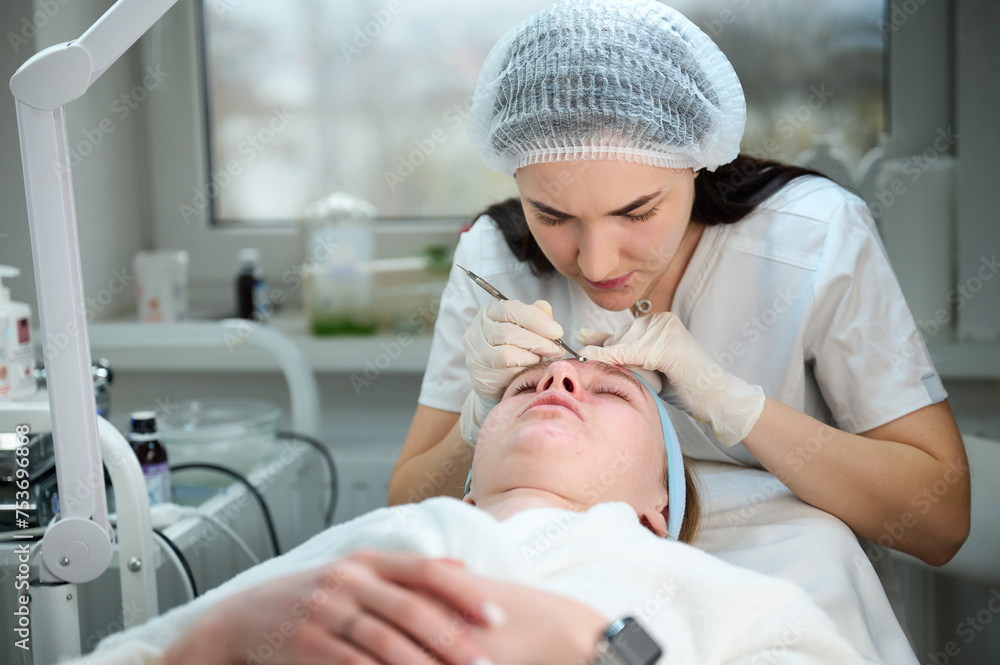 Close up of ultrasound skin cleaning and facial peeling procedure in beauty clinic. Macro shot of woman under procedure of ultrasonic facial. Deep pore cleansing treatment Close up of ultrasound skin cleaning and facial peeling procedure in beauty clinic. Macro shot of woman under procedure of ultrasonic facial. Deep pore cleansing treatment