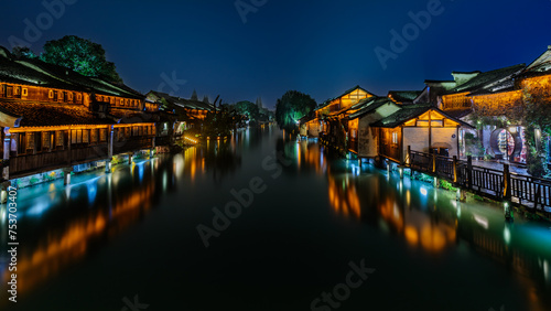 Attractive night scenery of traditional Chinese houses on both banks of a canal in a chilly and rainy evening at the ancient township of Wuzhen near Shanghai, China. photo