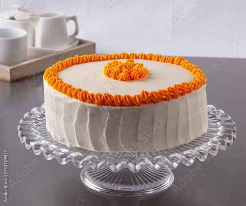 Carrot cake covered with cream cheese and decorated with carrot cream