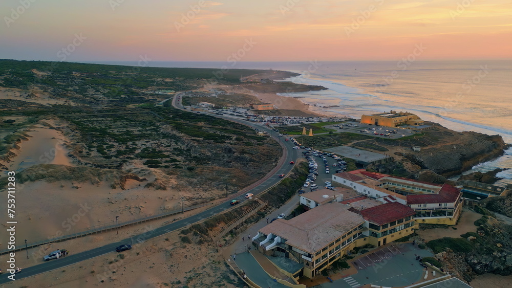 Cozy coastal resort evening twilight aerial view. Ocean waves washing coastline