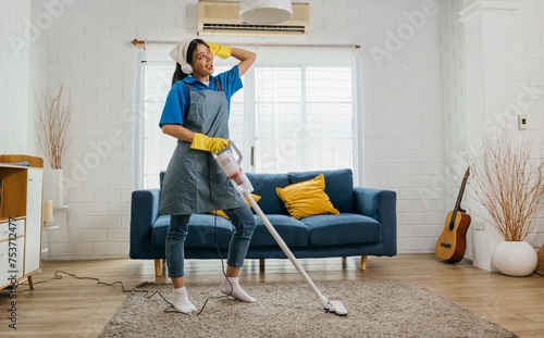 Happy maid's cleanup melody, Asian woman uses mop as mic singing dancing. Fun-filled service with music laughter and excitement. Modern domestic joy. Give me a beat, maid dancing having fun