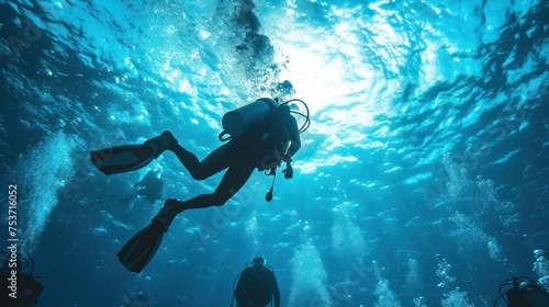 Diver surrounded by a school of fish in a sunlit underwater scene