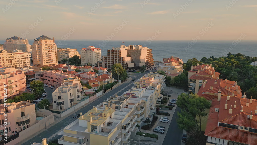 Drone twilight coastal town placed at endless ocean. Wonderful seaside town