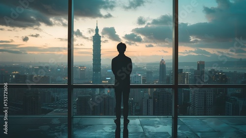 Silhouetted Man Contemplating City Skyline in Taipei photo