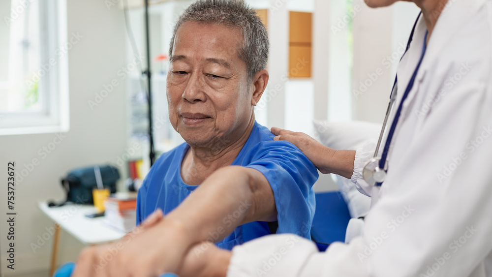 An elderly Asian man is doing physical therapy with the support of an elderly female nurse using dumbbells and tubes to exercise for a patient. An elderly Asian man is doing physical therapy with the support of an elderly female nurse using dumbbells and tubes to exercise for a patient.