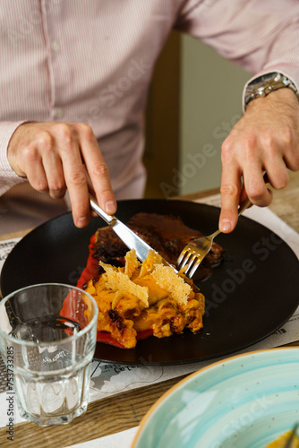 Man eating mac and cheese and slices of meat