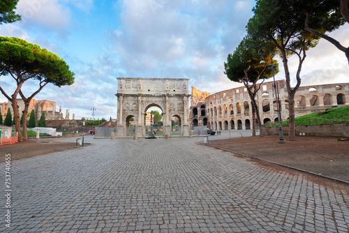 Arch of Constantine and Colosseum with empty alley road, antique Rome city, Italy photo
