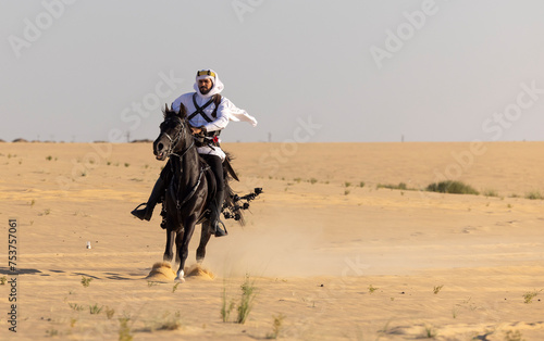 Rider in the desert of Saudi Arabia with his back stallion