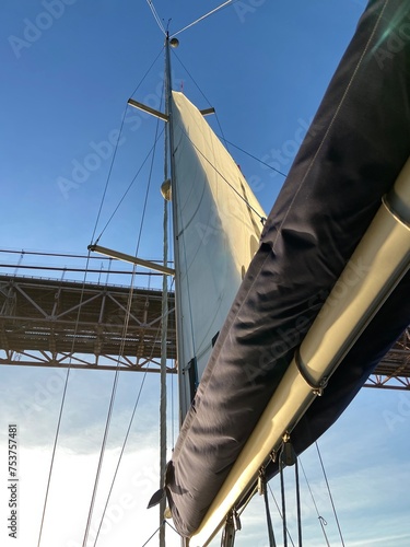 sailboat mast and rigging under bridge