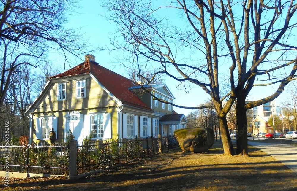 Early spring in town. A calm, sunny street with a beautiful old house of the Municipal Museum of Ancient Decorative and Applied Arts. Europe, Latvia, Riga. Early spring in town. A calm, sunny street with a beautiful old house of the Municipal Museum of Ancient Decorative and Applied Arts. Europe, Latvia, Riga.