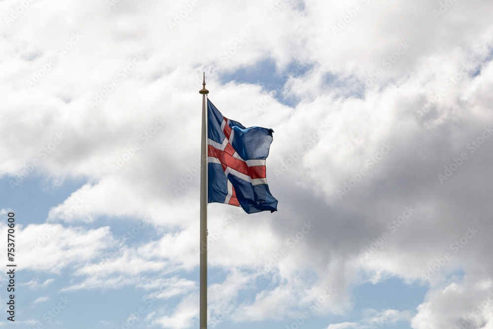 iceland flag fluttering on a flagpole at the rauðisandur beach in iceland on a cloudy day