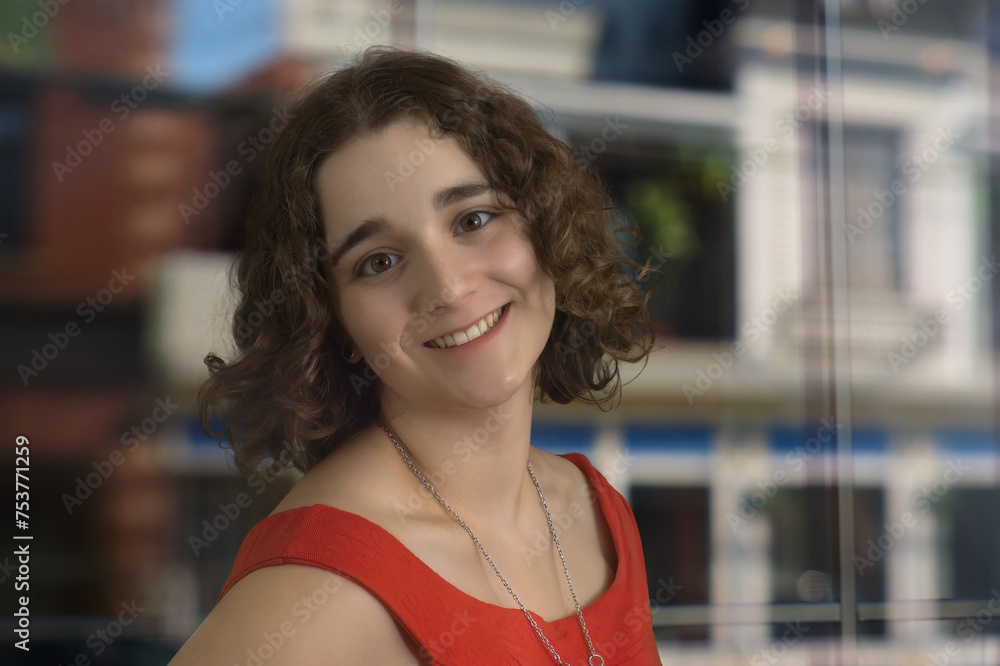 young woman student sitting in office curly hair brunette red dress in front of window young woman student sitting in office curly hair brunette red dress in front of window