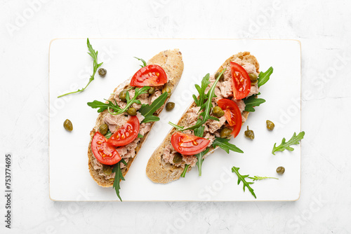 Tuna caper toasts with arugula, tomatoes and whole rye bread, top view