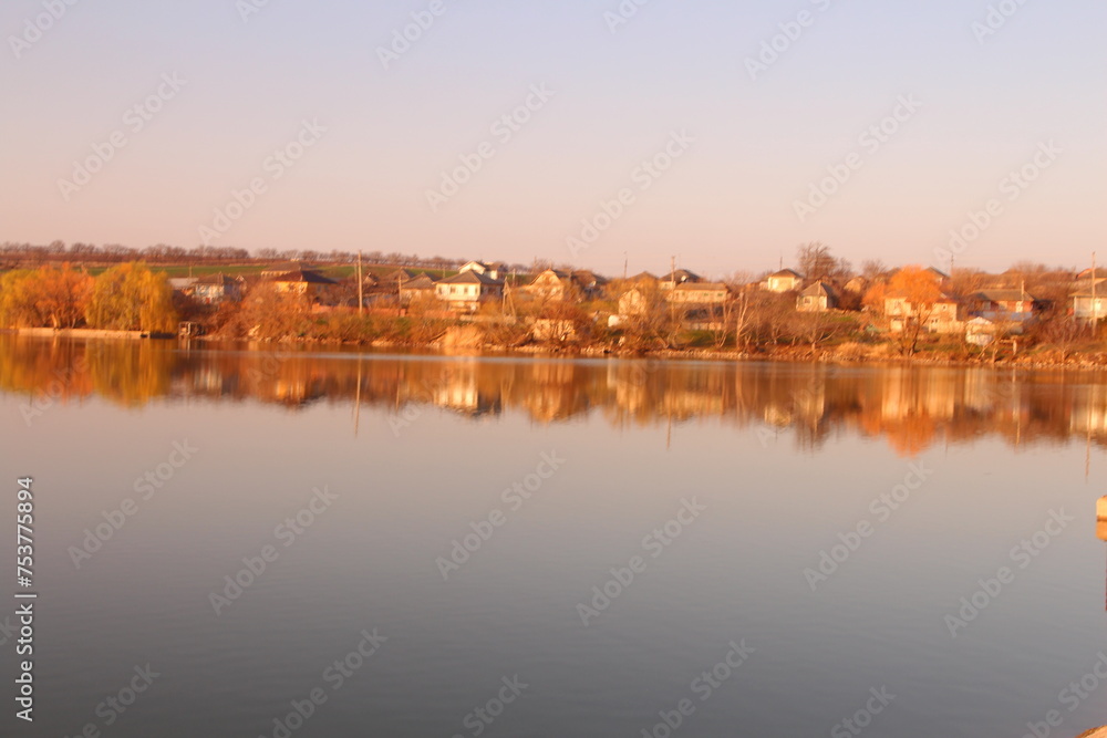 A body of water with trees and buildings in the background