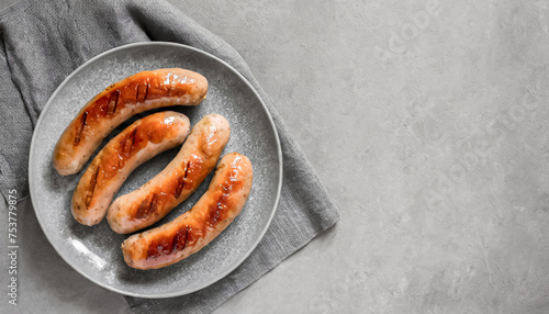 grilled sausage. top view of grilled sausage on grey plate, copy space