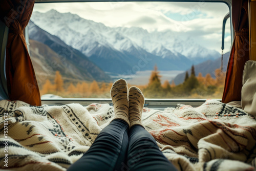 half length, of the crossed feet of a young woman, lying on the bed of her campervan, photo