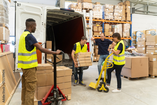 Busy Warehouse Workers Unloading Delivery Van photo