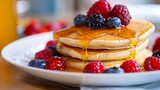 A plate of fluffy pancakes topped with fresh berries and a drizzle of honey
