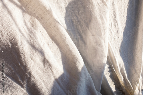 Close-up of neutral beige linen and soft sunlight
