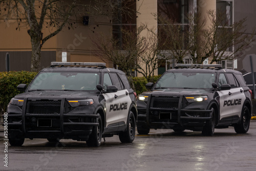 Fotografie Police cruisers SUV responding to suspiscious activity in parking lot on rainy d