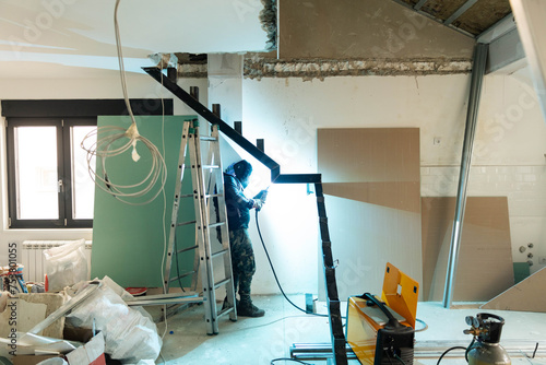 Welder works on the staircase framework. photo