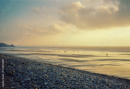 Distant figures enjoying the sunset on a beach photo