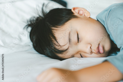Asian boy sleeping on white bed. New family, protection, relaxation and relationship concepts.