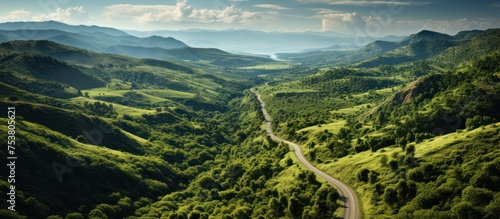 Top view of country road amidst green mountain landscape photo