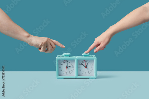 Crop of male and female hands pressing button on chess clock photo