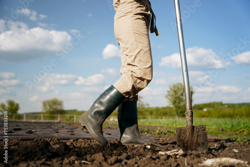 Feet in boots with a shovel photo