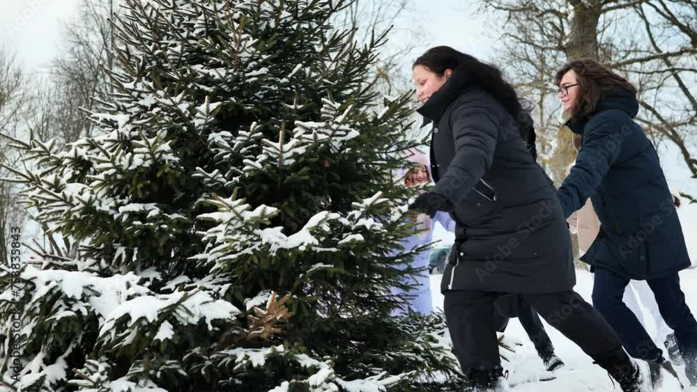 School friends run around the spruce tree holding hands. Christmas concept. School friends run around the spruce tree holding hands. Christmas concept.