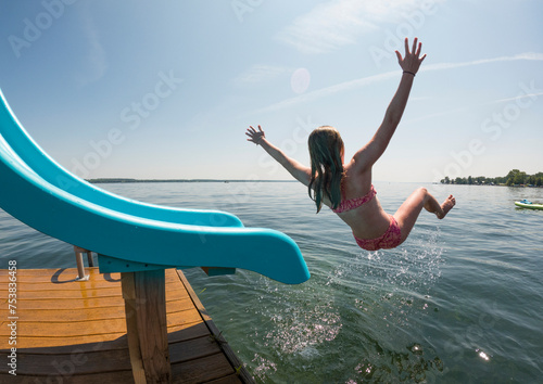 Young girl Swimming at finger lakes lake on slide in summer vacation  photo