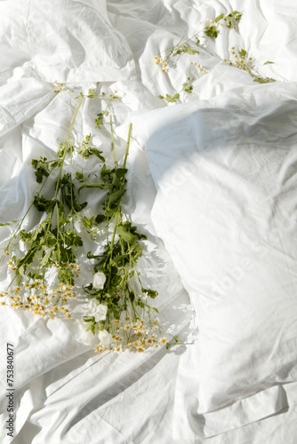 white flowers lie on a white blanket photo