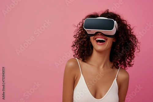 Portrait of sexy emotional laughing woman wearing white augmented virtual reality glasses on pink color studio background with copy space 
